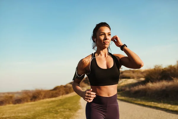 Young Athletic Woman Listening Music Earphones While Jogging Nature Copy —  Fotos de Stock