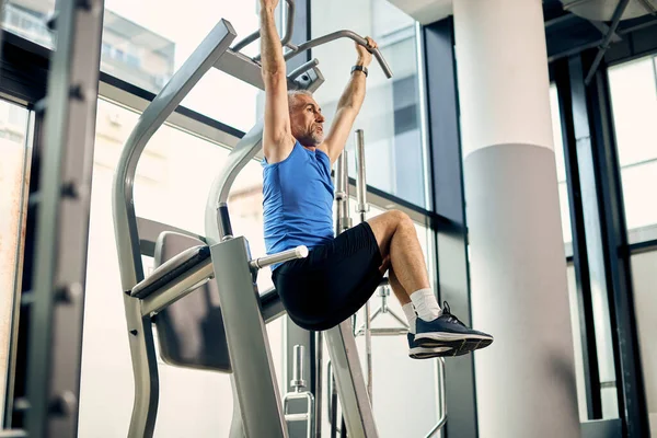 Low Angle View Mature Athlete Practicing Knee Raise Machine While — ストック写真