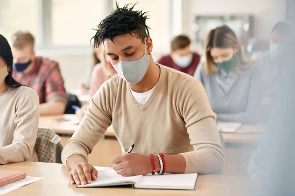 African American Student Writing Notebook While Wearing Face Mask Attending — Foto Stock