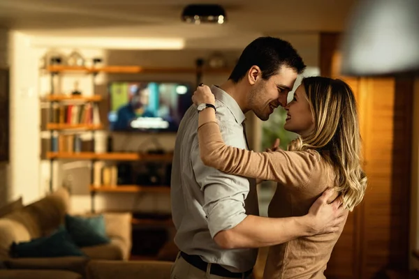 Happy couple in love touching noses while dancing at home. 