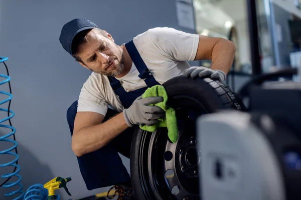 Mid Adult Car Mechanic Cleaning Tire While Working Repair Shop — Fotografia de Stock