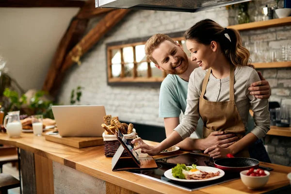 Happy Woman Using Digital Tablet Communicating Her Husband While Cooking — Stockfoto