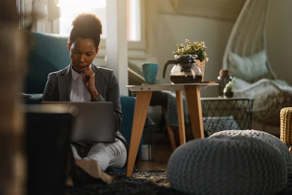 Thoughtful African American Businesswoman Working Computer While Siting Floor Home — Photo