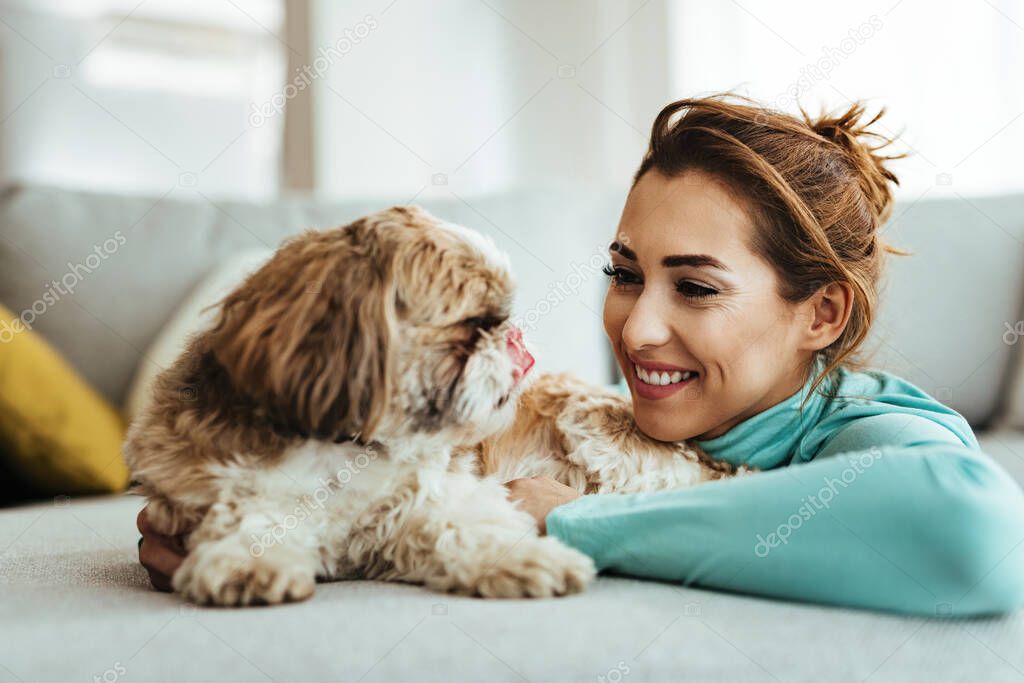 Young happy woman enjoying with her dog at home. 