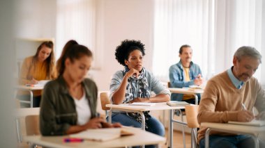 African American female student paying attention during lecture in the classroom. 