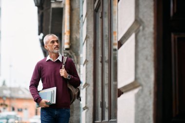 Smiling mature student coming to university library to study. 