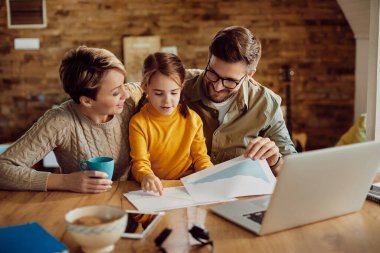 Happy family having fun while going through paperwork at home. 