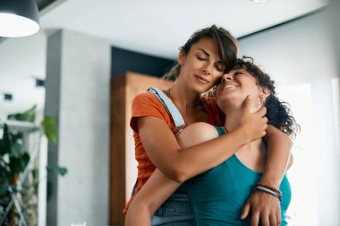 Genç bayan çift evde birlikte vakit geçirirken birbirlerine sevgi gösteriyorlar..