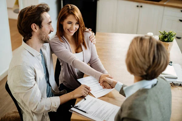 Young Happy Couple Shaking Hands Insurance Agent While Having Meeting — Fotografia de Stock