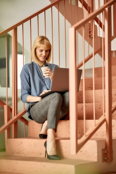 Female Entrepreneur Relaxing Staircase Drinking Coffee While Using Laptop —  Fotos de Stock