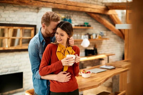 Affectionate Man Embracing His Girlfriend Who Having Cup Coffee Home — Zdjęcie stockowe