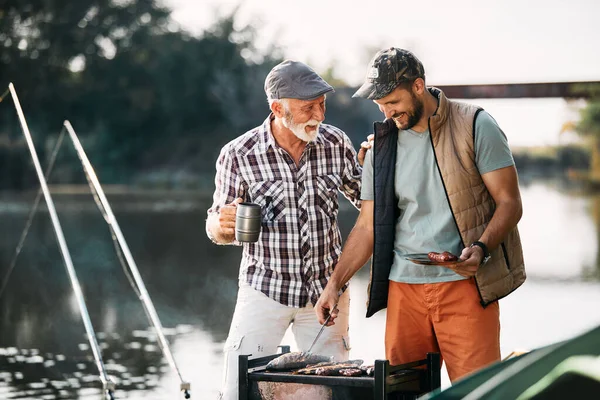 Happy Man Preparing Barbecue His Senior Father While Camping Together — Stok fotoğraf