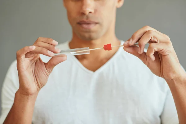Close-up of man taking PCR test with cotton swab.