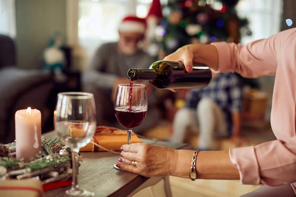 Close0 Mature Woman Pouring Red Wine Wineglass While Celebrating Christmas — ストック写真
