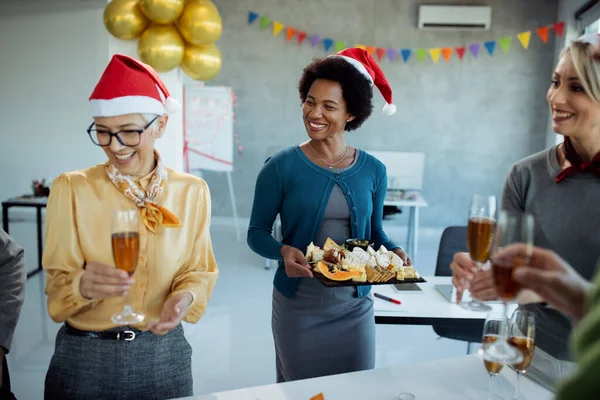 Happy Black Businesswoman Serving Food While Celebrating Coworkers Christmas Party — ストック写真