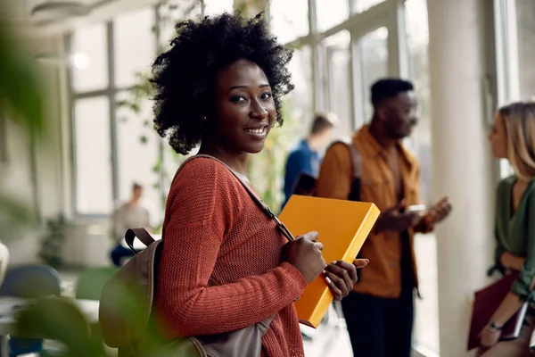 Χαρούμενος Αφροαμερικανός Φοιτητής Που Στέκεται Στο Διάδρομο Και Κοιτάζει Την — Φωτογραφία Αρχείου
