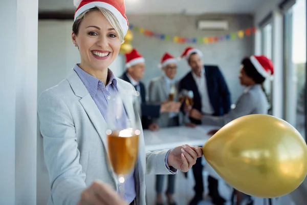 Happy Businesswoman Holding Balloon Toasting Champagne While Celebrating Christmas Party — ストック写真