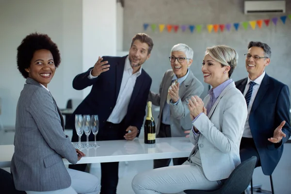 Happy business coworkers celebrating in the office and waiting for someone to come to the party.