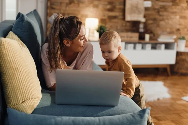 Happy Mother Using Laptop Her Small Son While Lying Sofa — Φωτογραφία Αρχείου