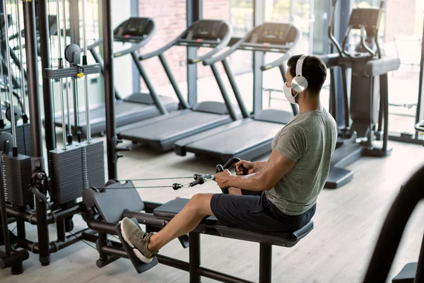 Athletic Man Working Out Rowing Machine While Wearing Face Mask — Φωτογραφία Αρχείου