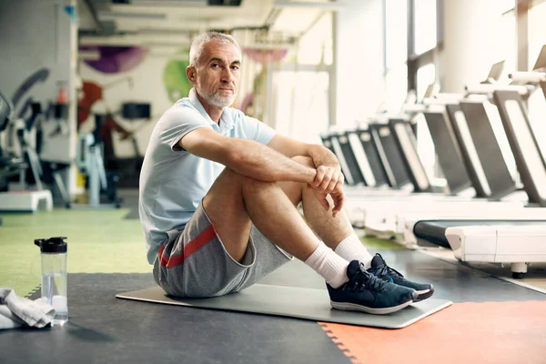 stock image Mature athletic man taking break during sports training in gym a