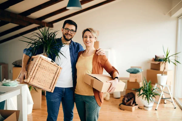 stock image Happy embraced couple relocating into a new home and looking at camera. Copy space. 