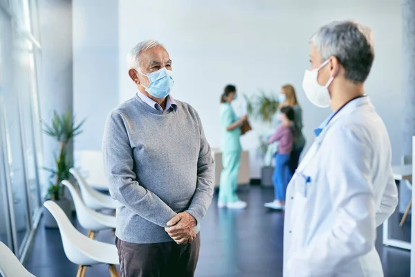 Mature Man His Doctor Wearing Face Masks While Communicating Lobby — 스톡 사진