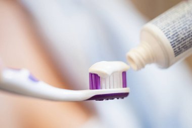 Close-up of applying toothpaste on a toothbrush. 