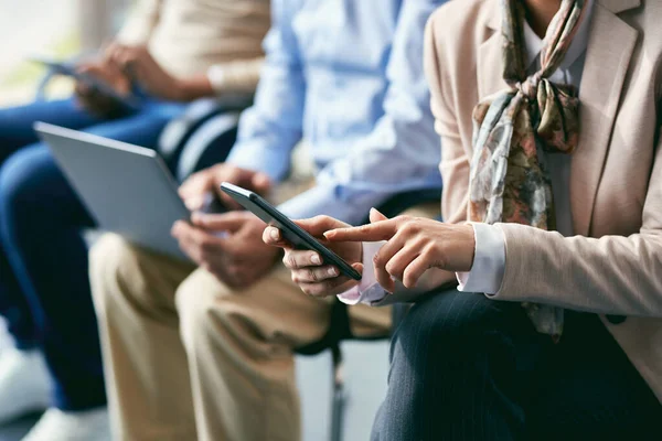 Close-up of businesswoman waiting for job interview and  text messaging on mobile phone.