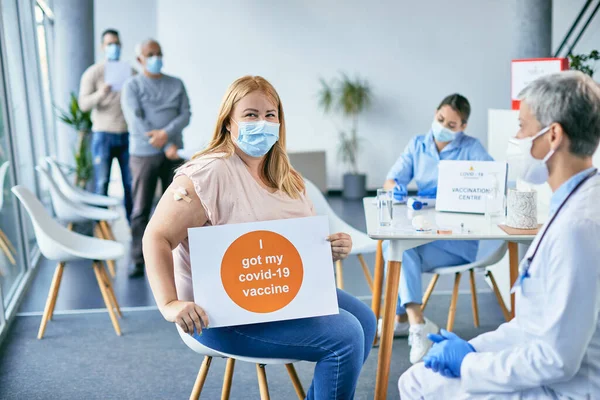 Happy woman wearing face mask and showing placard with \