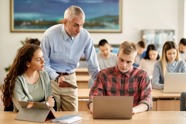 Mature University Teacher Talking His Students Who Learning Computer Lecture — Stockfoto