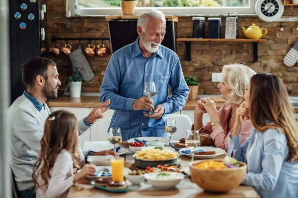 Szczęśliwy Dojrzały Mężczyzna Proponując Toast Rozmawiając Rodziną Podczas Lunchu Jadalni — Zdjęcie stockowe