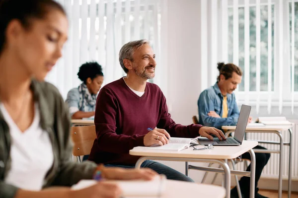 Happy Mature Student Writing Notes Using Laptop While Learning Class — Stock Fotó