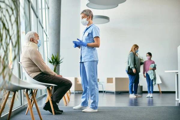 Senior Man Injured Neck Talking Nurse Waiting Room Clinic Wearing — Stockfoto