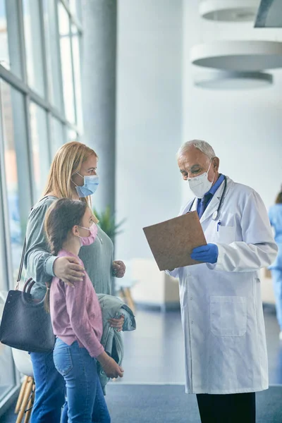 Senior Pediatrician Explaining Medical Examination Data Mother Daughter Hospital Covid — Foto Stock