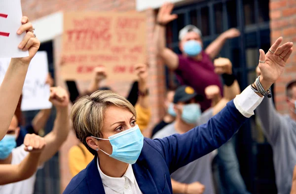 Caucasian woman with protective face mask with Black Lives Matter protesters on city streets.