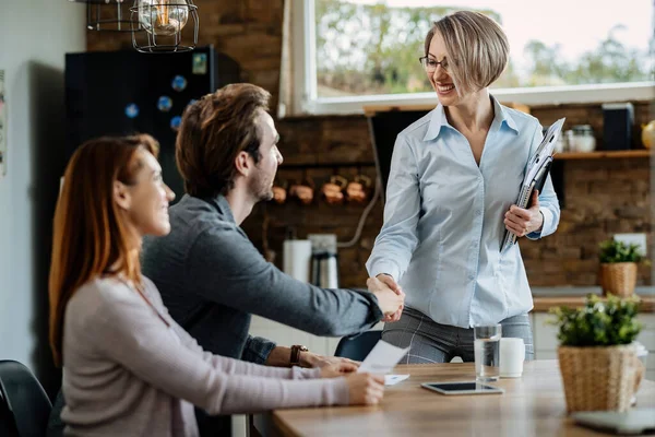 Happy Financial Advisor Greeting Young Couple Home Shaking Hands Man — ストック写真