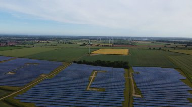 High Angle Aerial view of Drone's Footage of Renewable Solar Panel Power and Windmill Wind Turbine Farms at Countryside of England UK,