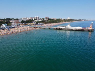 High Angle Footage and Aerial view of Ocean with High Speed Boats, People are having fun and enjoying hottest weather at Bournemouth Beach Sea Front of England UK.