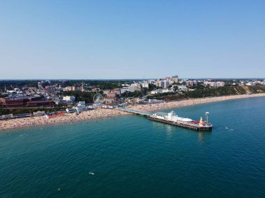High Angle Footage and Aerial view of Ocean with High Speed Boats, People are having fun and enjoying hottest weather at Bournemouth Beach Sea Front of England UK.
