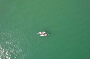 Yüksek Açı Görüntü ve Yüksek Hız Tekneleri ile Okyanus, İngiltere 'nin Bournemouth Sahil Cephesi' nde insanlar eğleniyor ve en sıcak havanın tadını çıkarıyorlar..