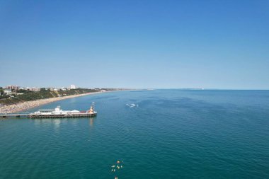 Yüksek Açı Görüntü ve Yüksek Hız Tekneleri ile Okyanus, İngiltere 'nin Bournemouth Sahil Cephesi' nde insanlar eğleniyor ve en sıcak havanın tadını çıkarıyorlar..