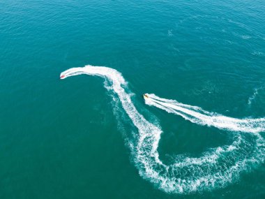 Yüksek Açı Görüntü ve Yüksek Hız Tekneleri ile Okyanus, İngiltere 'nin Bournemouth Sahil Cephesi' nde insanlar eğleniyor ve en sıcak havanın tadını çıkarıyorlar..