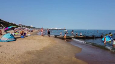İnsanlar İngiltere 'nin Bournemouth Sahili' nde yazın sıcak havasının tadını çıkarıyorlar.