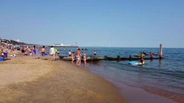 İnsanlar İngiltere 'nin Bournemouth Sahili' nde yazın sıcak havasının tadını çıkarıyorlar.