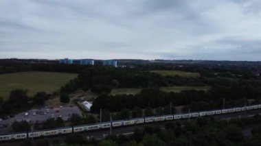 Aerial View and high angle footage of British Railways Trains on Tracks, Passing Through Luton Town of England at Leagrave Station, Cloudy Day