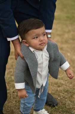 Asyalı Pakistanlı Baba 11 aylık bebeğini Londra Luton İngiltere 'deki yerel parkında tutuyor.