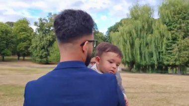 Asian Pakistani Father is holding his 11 Months Old Infant at Local Park of Luton Town of England UK