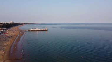 İnsanlar İngiltere 'nin Bournemouth kumlu plajında, güzel Britanya Deniz Manzarası ve Büyük Britanya' nın Temiz Okyanusu 'nda eğleniyor ve dinleniyorlar.