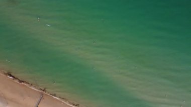 İnsanlar İngiltere 'nin Bournemouth kumlu plajında, güzel Britanya Deniz Manzarası ve Büyük Britanya' nın Temiz Okyanusu 'nda eğleniyor ve dinleniyorlar.